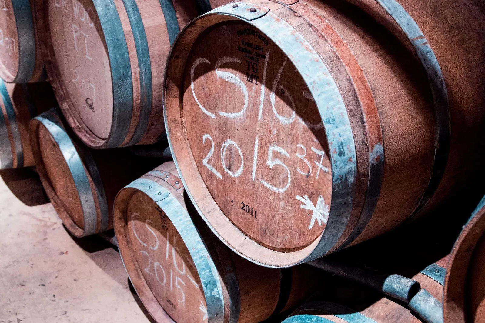 Barrique barrels with chalk annotations in the estate cellar