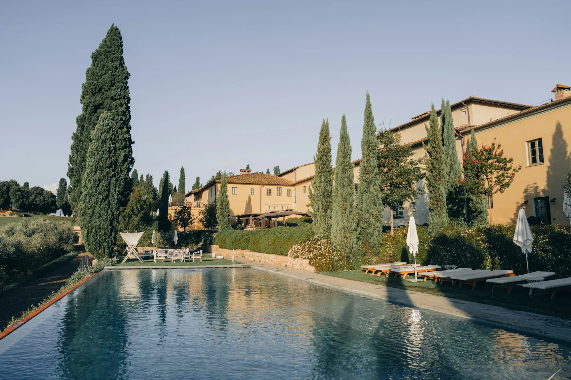 Farm stay swimming pool with Tuscan buildings and Chianti cypress trees, B&B Il Vigneto