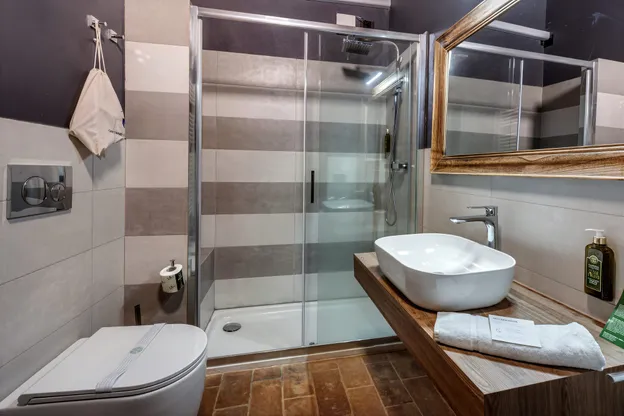 Il bagno del Fienile, con la doccia e il lavabo appoggiato sul piano di legno