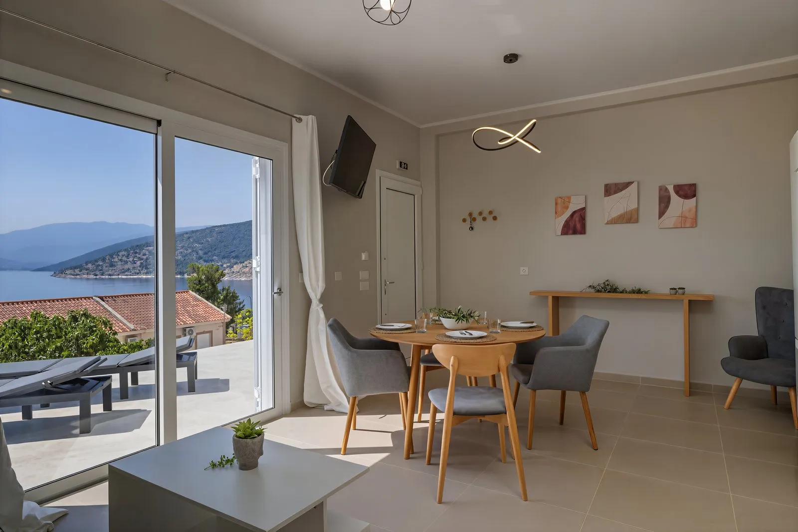 Il tavolo da pranzo davanti alla vetrata sul terrazzo, con la vista sul mare