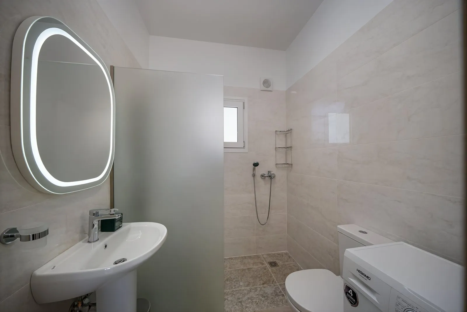 Il bagno, con il lavabo e la doccia dietro il vetro
