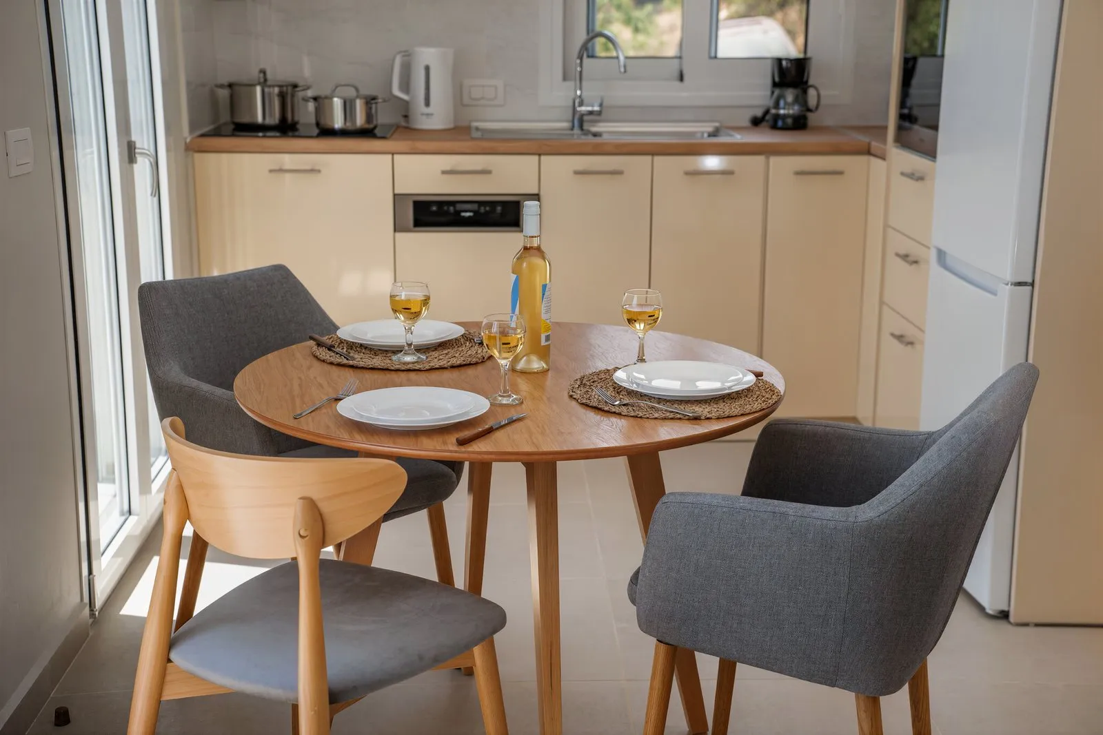 La tavola apparecchiata, con i bicchieri e il vino bianco